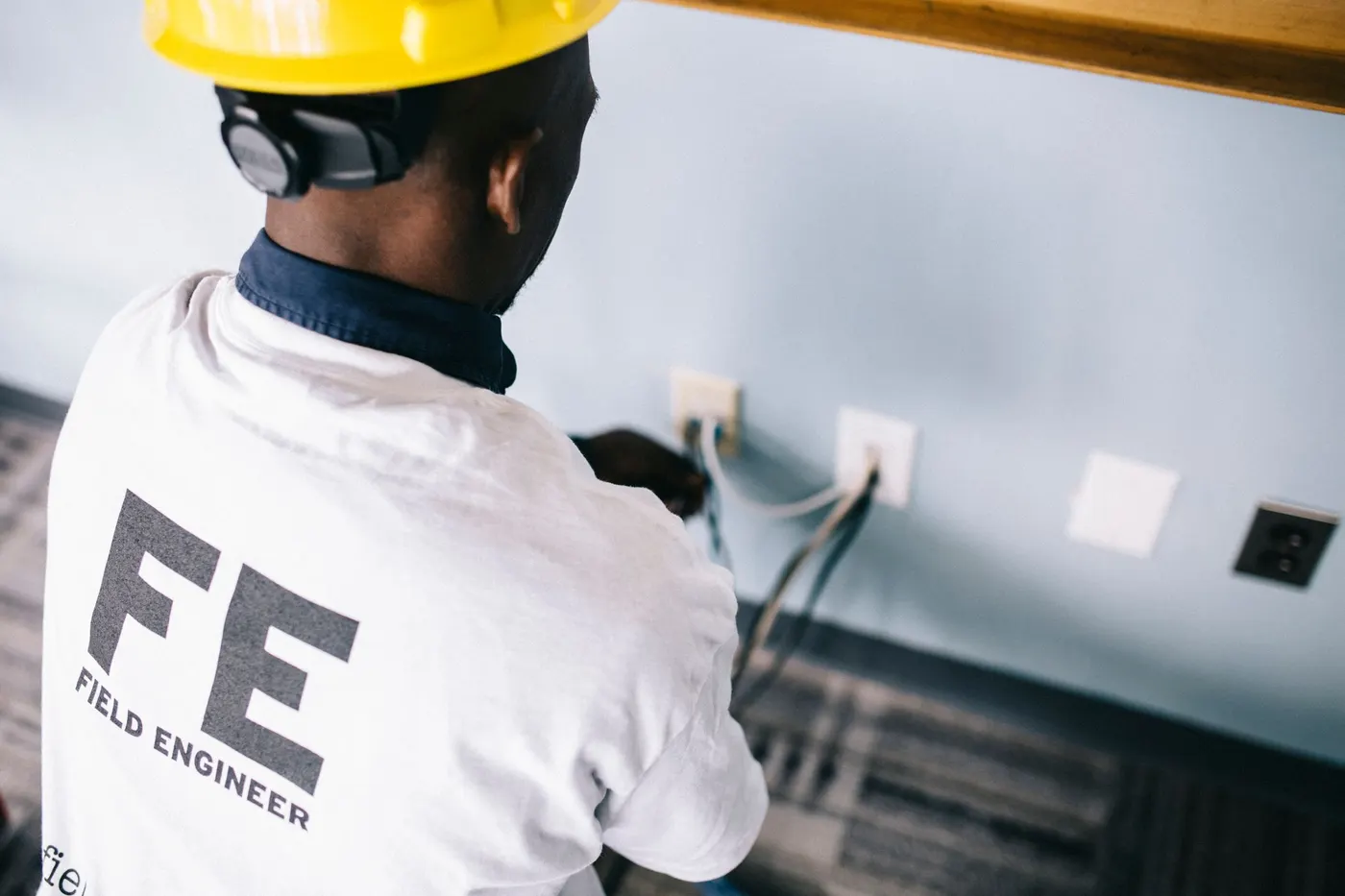 Field engineer testing wall sockets during an on-site service visit
