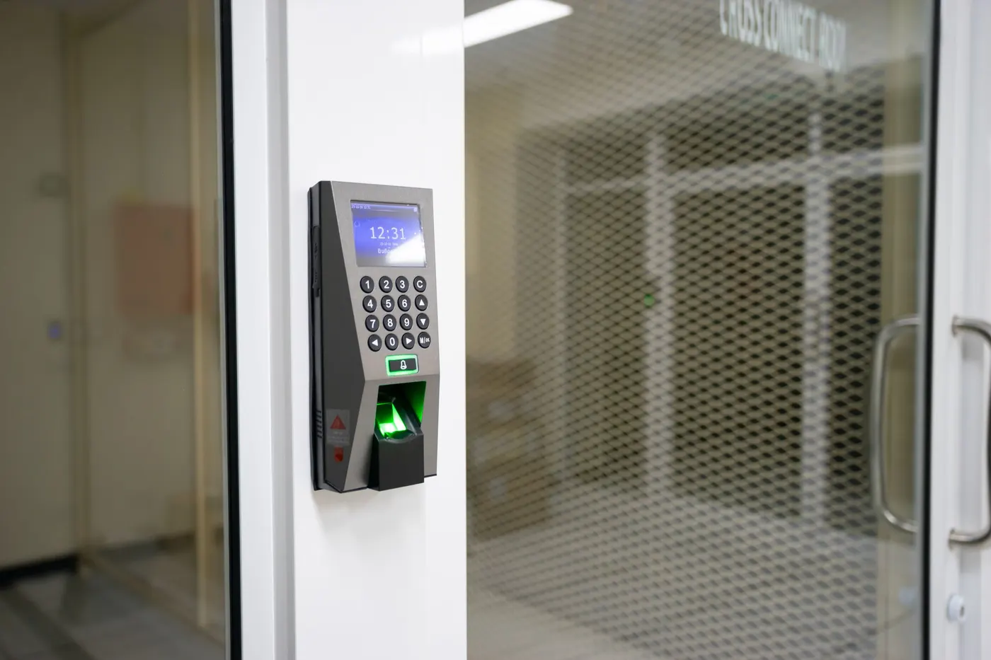 Fingerprint scanner terminal with keypad mounted beside an office door