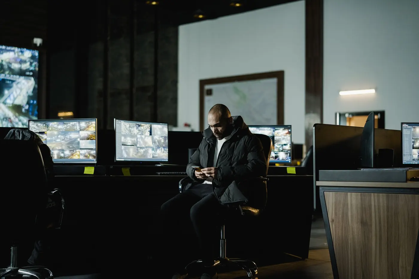 Security operator in a control room with multiple CCTV monitoring screens