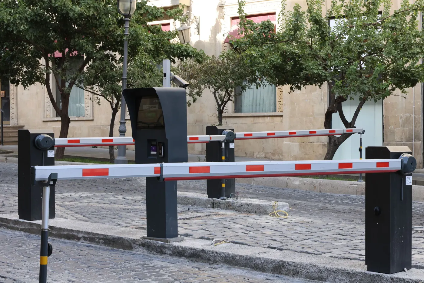 Boom barriers at a parking entrance with ticket machine