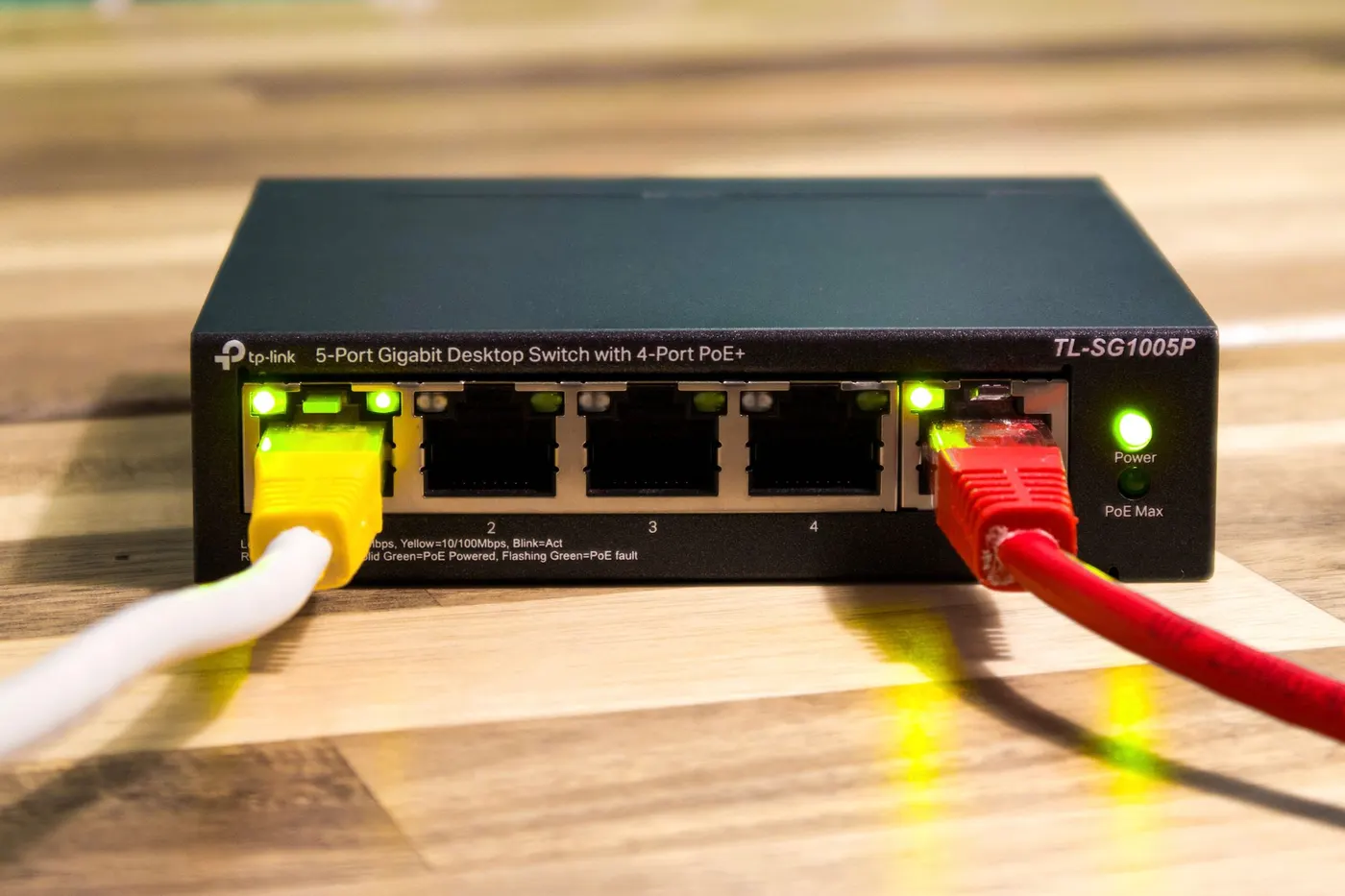 Desktop gigabit PoE network switch with connected Ethernet cables