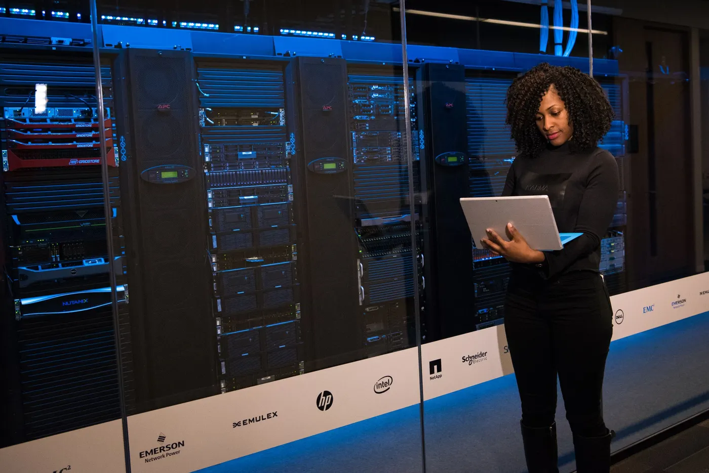 Engineer with a laptop beside server racks in a data centre