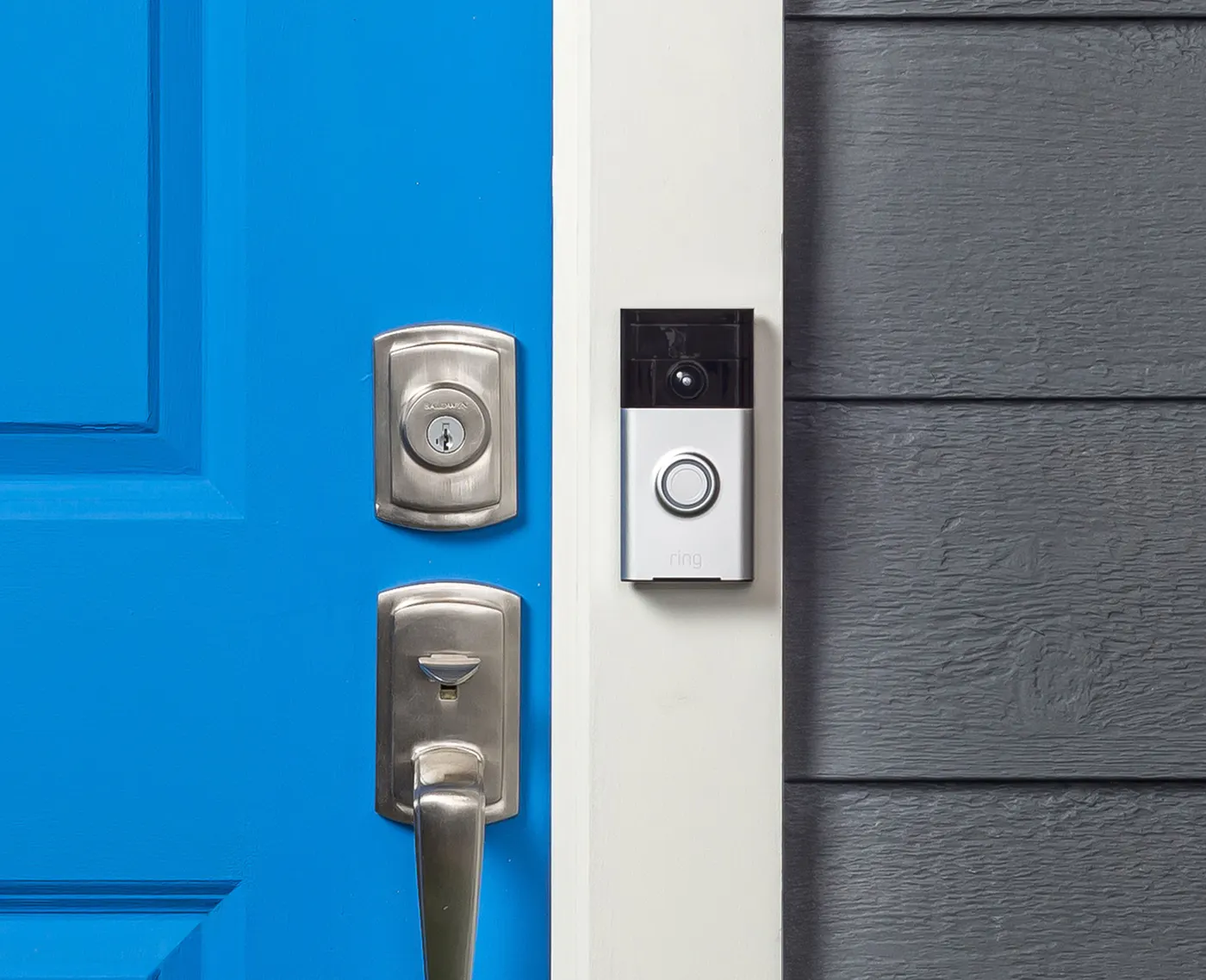 Video doorbell beside a front door with keypad deadbolt and handle set