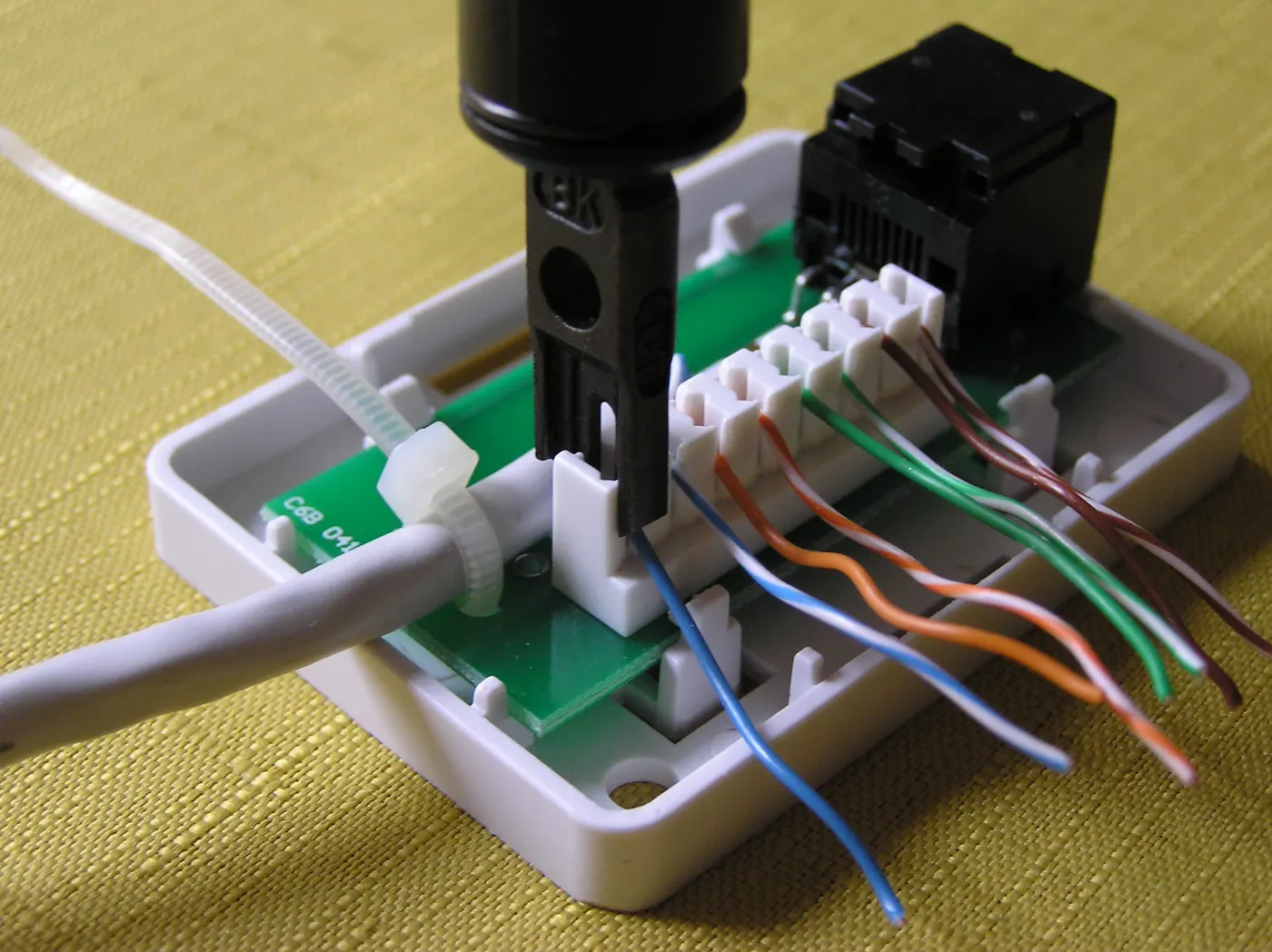 Punch-down tool terminating network cable pairs into a keystone jack