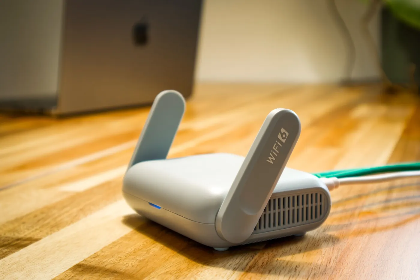 Wi-Fi 6 router with antennas on a wooden desk